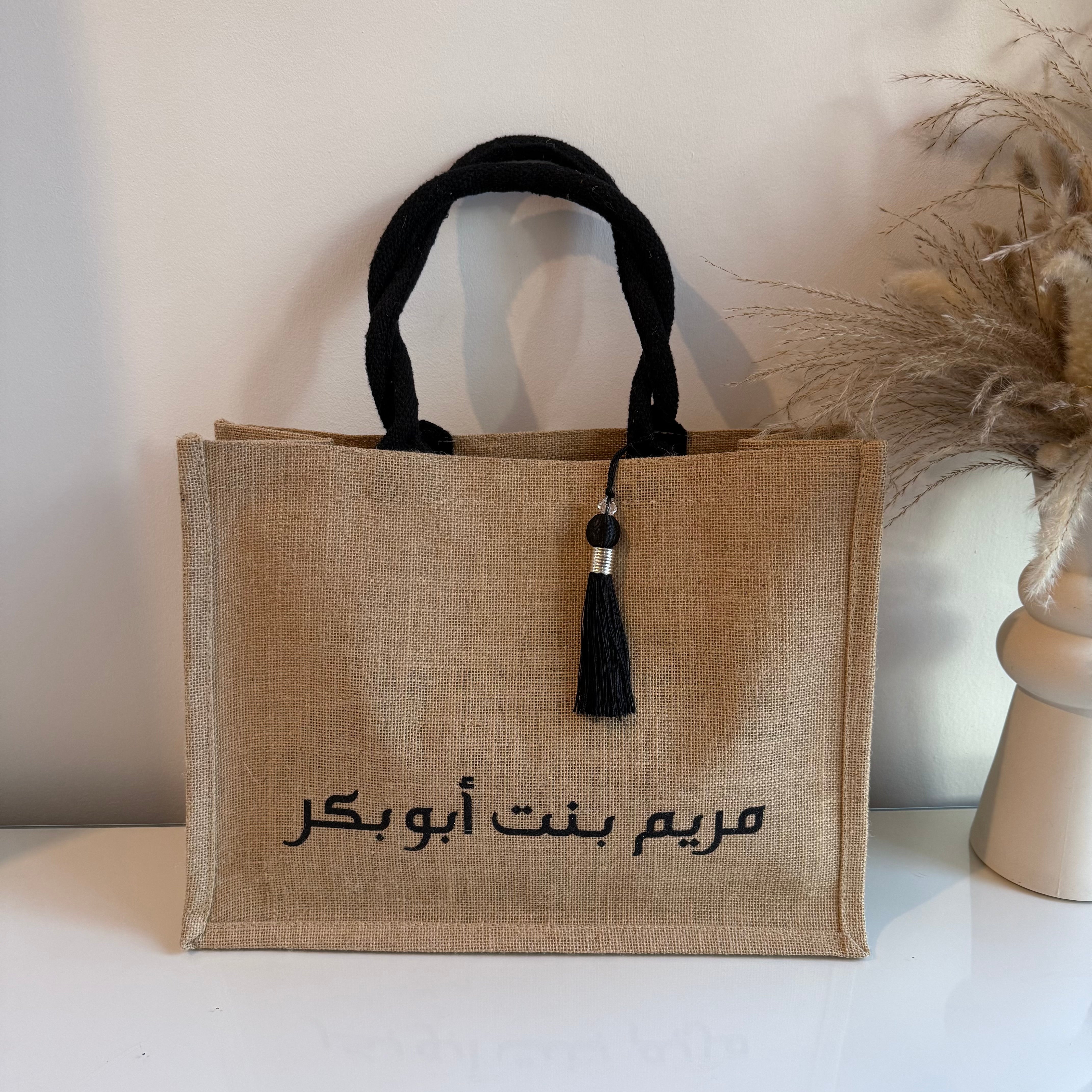 Sac en Toile de Jute avec Pompon Noir et Personnalisé avec Prénom en Calligraphie Arabe centré