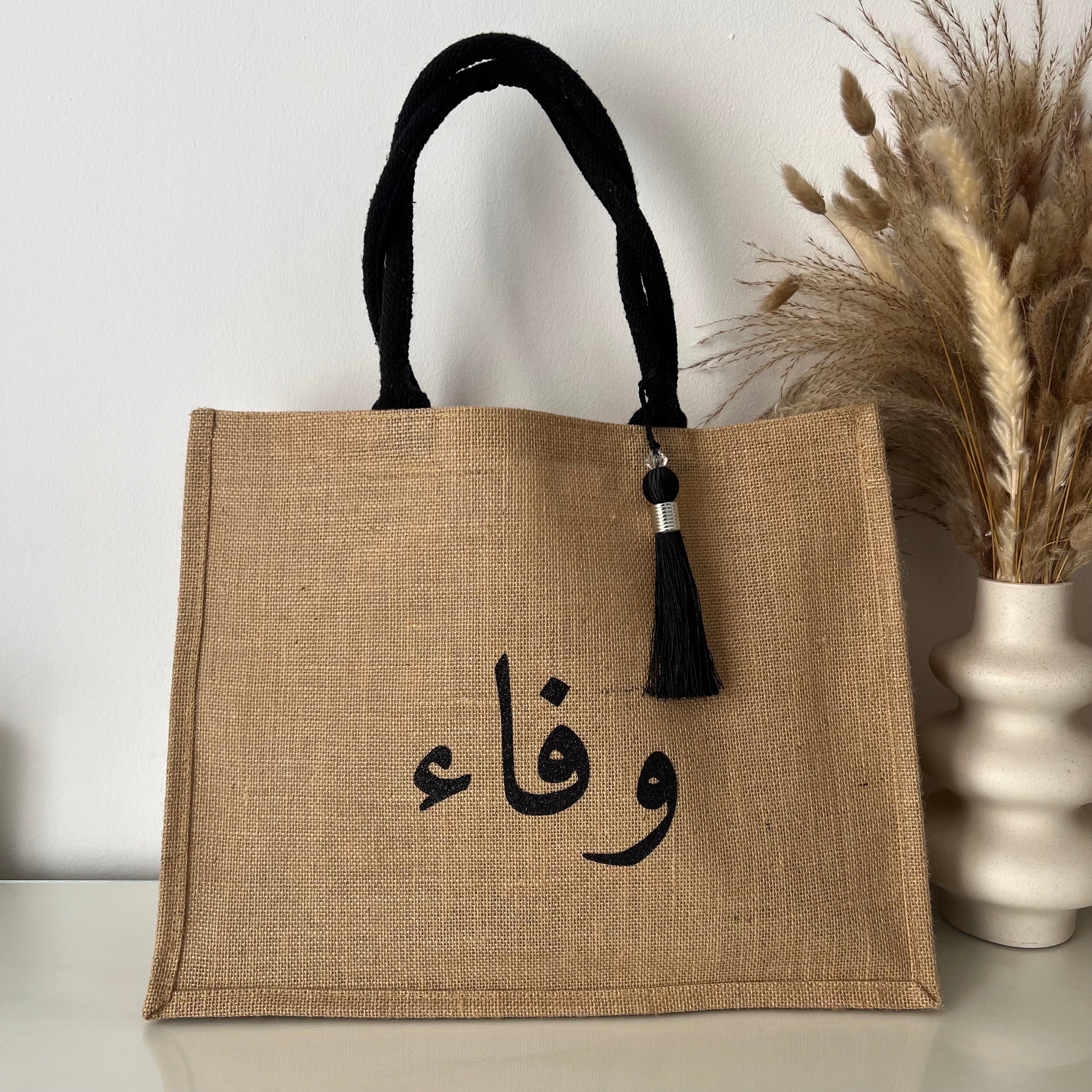 Sac en Toile de Jute avec Pompon Noir et Personnalisé avec Prénom en Calligraphie Arabe centré